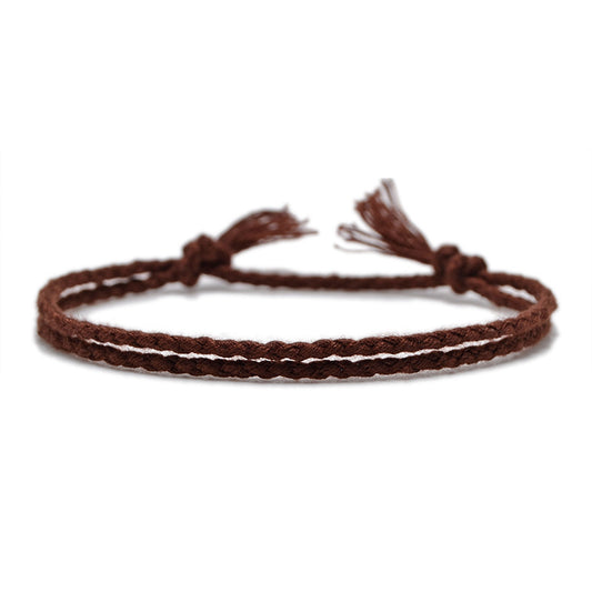 A deep brown braided bracelet with a handwoven design and adjustable knotted closure, capturing an earthy and rustic style.