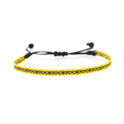 Yellow woven bracelet with black geometric patterns and adjustable black cord.