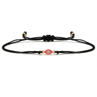 Black cord bracelet with a decorative clasp on a white background