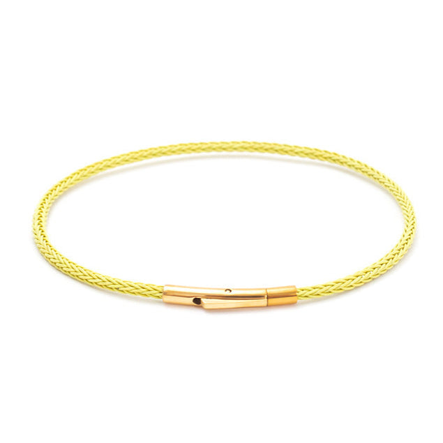 Yellow braided bracelet with gold clasp on a white background