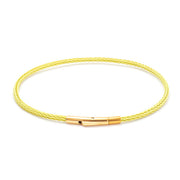 Yellow braided bracelet with gold clasp on a white background