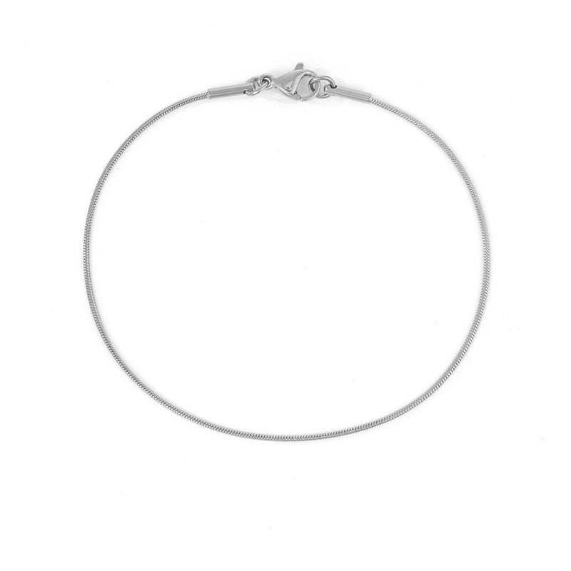 Minimalistic silver snake chain bracelet with lobster clasp, shown in a circular form.