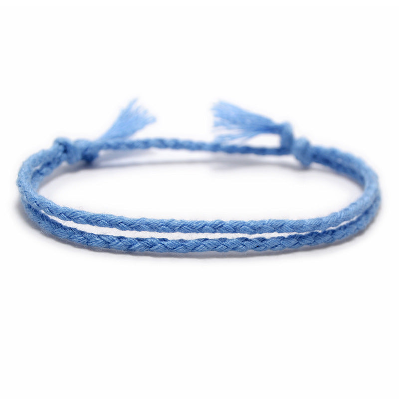 A minimalist light blue, hand-braided bracelet with adjustable ends.