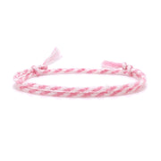 A soft pink and white braided friendship bracelet with tassel ends, laid flat on a white background.