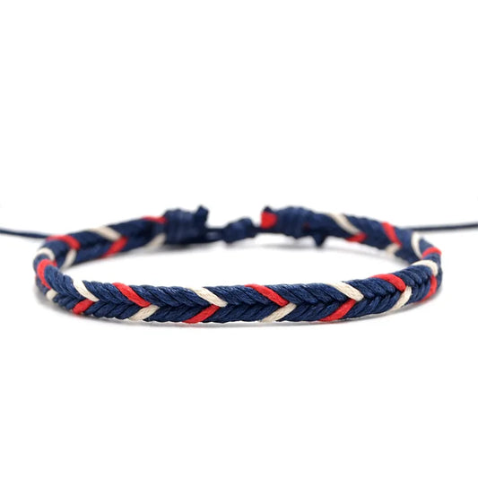 Navy blue woven rope bracelet with red and white accent threads, laid on a neutral surface
