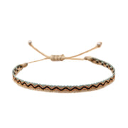 Flat woven bracelet featuring zig-zag patterns in black, turquoise, and tan, resembling traditional coastal motifs.