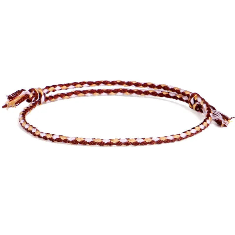Handwoven bracelet in soft sand and cream tones with a double braid design, inspired by earthy Mediterranean textures.