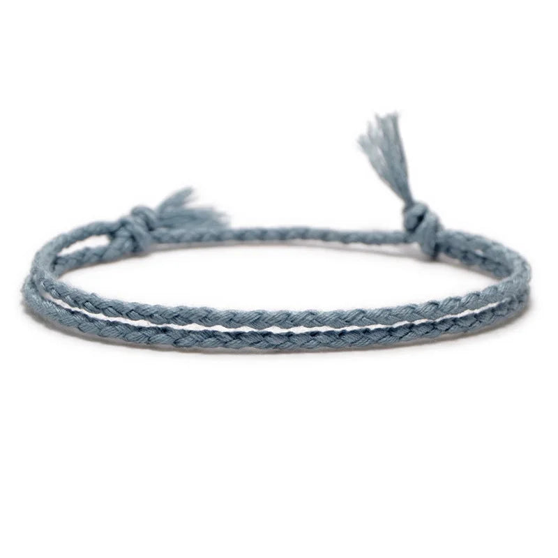 Light grey braided rope bracelet, adding a soft, textured layer to a wrist stack.