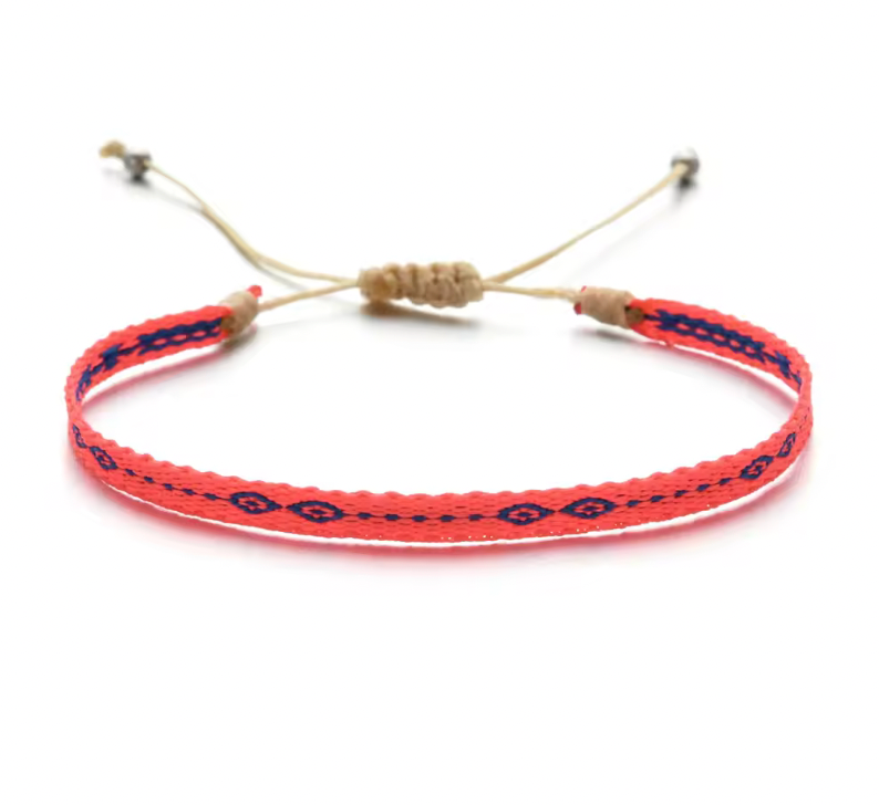 Coral red handmade bracelet with navy blue diamond pattern and beige adjustable cord.