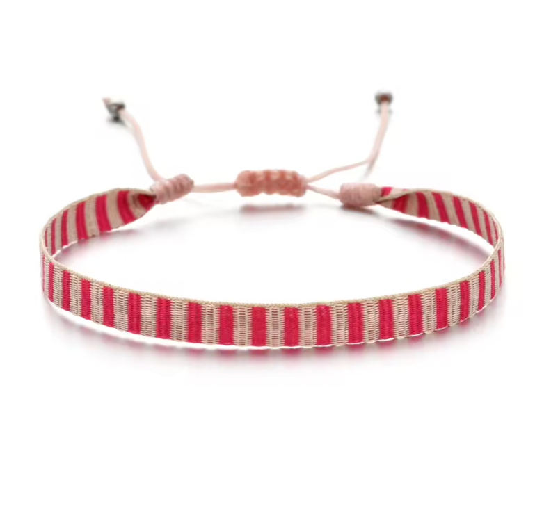 Handwoven striped bracelet in blush pink and cream with an adjustable pink cord.
