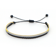 Minimal braided bracelet with black, silver, and yellow stripes, featuring adjustable black drawstring ends