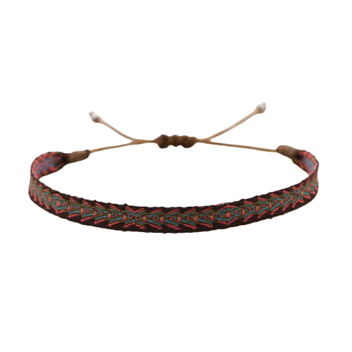 Handmade woven bracelet in red, green, and black with tribal-inspired pattern, displayed on a soft beige pedestal.