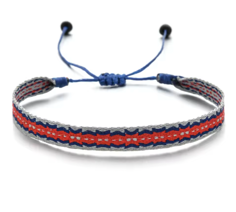 Handmade woven bracelet in red, navy, and grey colors, styled with an adjustable blue cord on a white reflective surface.