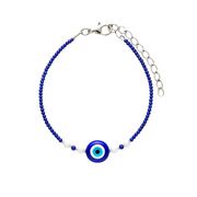 Handmade blue beaded bracelet with a central blue evil eye and white accent beads, featuring adjustable silver chain clasp.