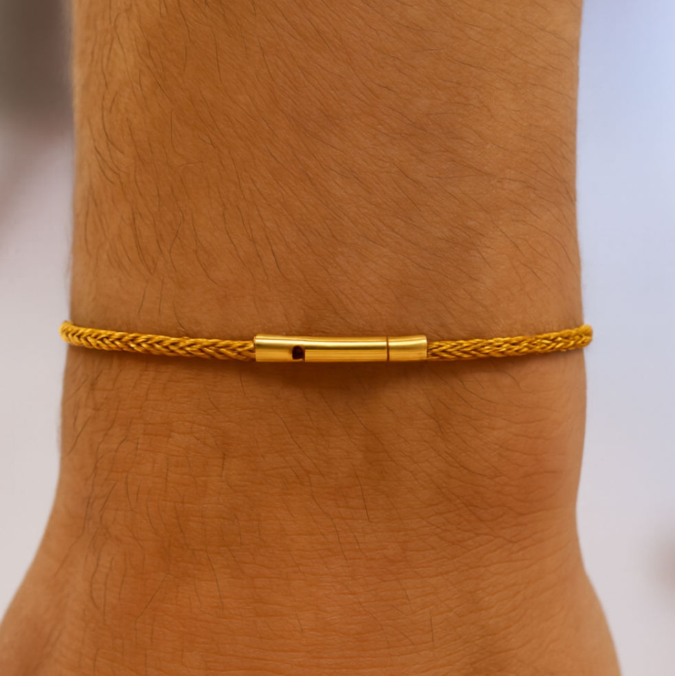 Gold braided bracelet on a wrist with a blurred background