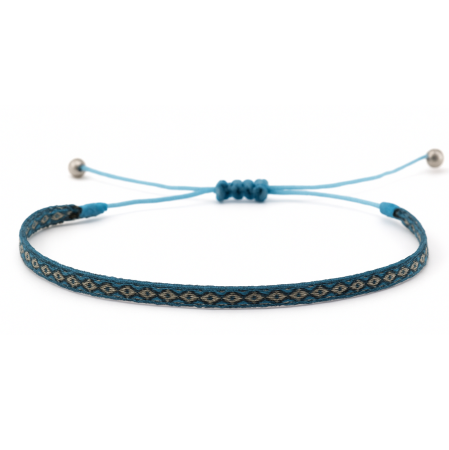 Woven bracelet with a blue and turquoise diamond pattern, worn on wrist alongside other bracelets.