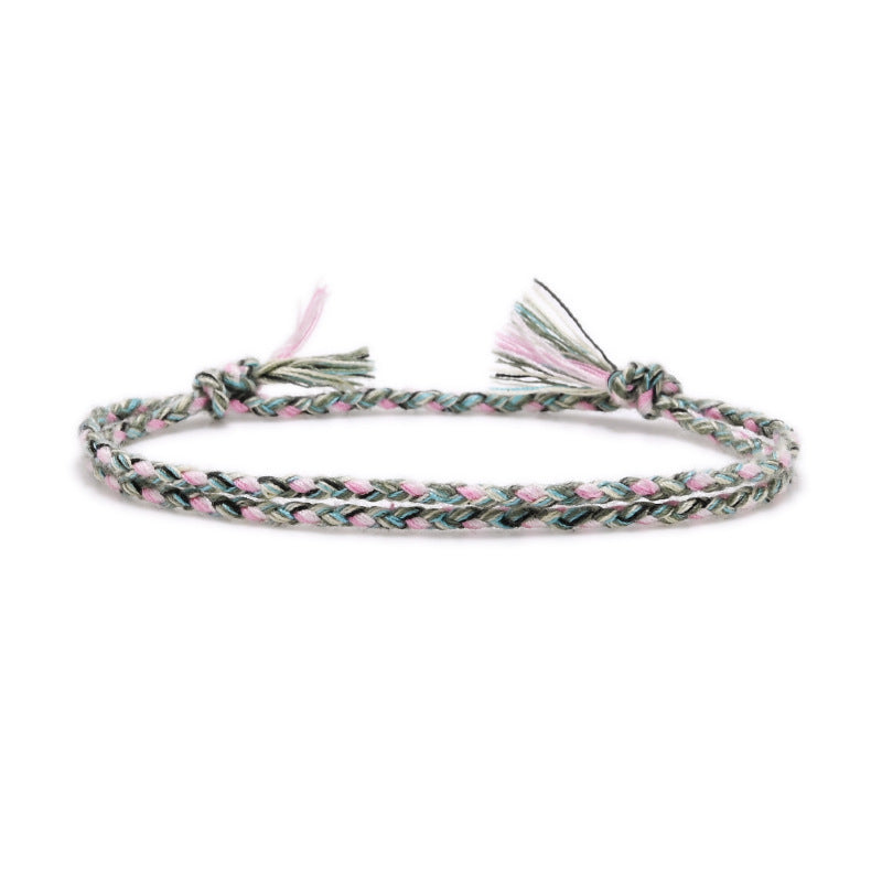 Braided bracelet with pink and green pattern on a white background
