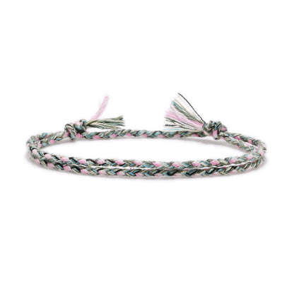 Braided bracelet with pink and green pattern on a white background