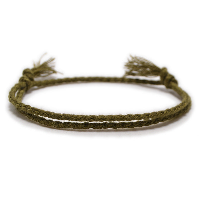 A minimalist light green, hand-braided bracelet with adjustable ends.