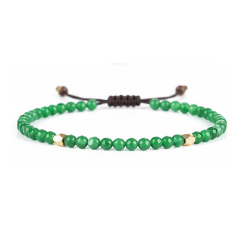 Green beaded bracelet with gold accents on a white background