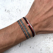 Close-up of a wrist wearing multiple bracelets on a light background