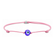 Pink bracelet with a blue evil eye charm on a white background