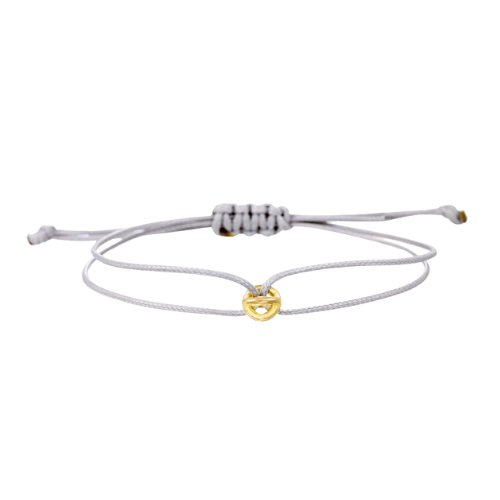 A stylish grey bracelet with a golden lucky charm, worn on the wrist as a symbol of fortune and elegance.